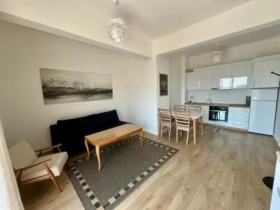 a living room with a table and a kitchen at Deluxe Apartment with Balcony and Sea View in Bar
