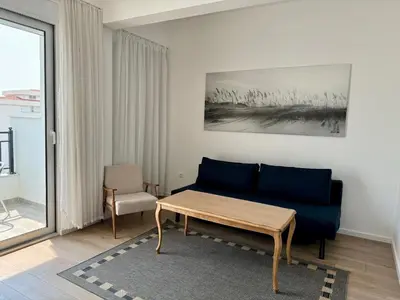 a living room with a blue couch and a table at Deluxe Apartment with Balcony and Sea View in Bar