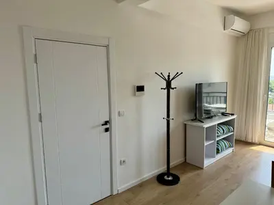 a white room with a door and a television at Deluxe Apartment with Balcony and Sea View in Bar