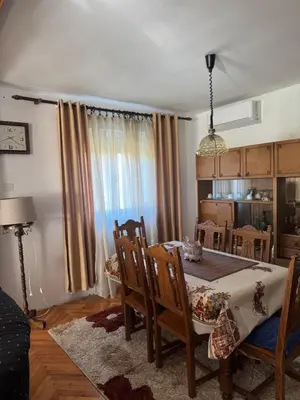 a dining room with a table and chairs in a room at Sweet house in Podgorica