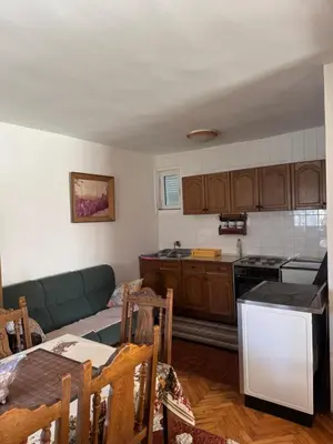 a living room with a couch and a kitchen at Sweet house in Podgorica