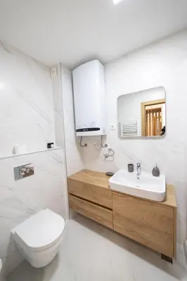 a white bathroom with a toilet and a sink at New City Luxury Apartments in Podgorica