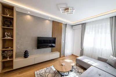 a living room with a couch and a tv at New City Luxury Apartments in Podgorica