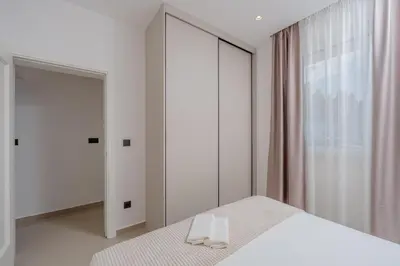 a bedroom with a white bed and a mirror at Bliss Apartments in Sutomore