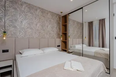 a bedroom with two beds and a mirrored wall at Bliss Apartments in Sutomore