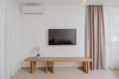 a table in a room with a television on a wall at Bliss Apartments in Sutomore