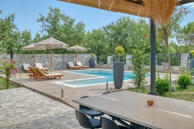 a swimming pool with a table and chairs and a patio at VILLA Amfora in Budva