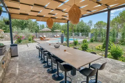 an outdoor patio with a long table and chairs at VILLA Amfora in Budva