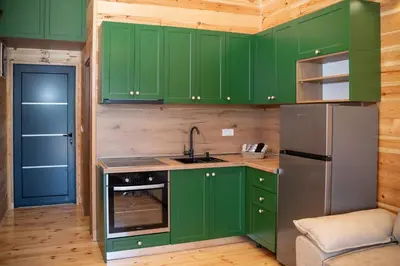 a kitchen with green cabinets and a refrigerator at River house - Esperanza in Ulcinj