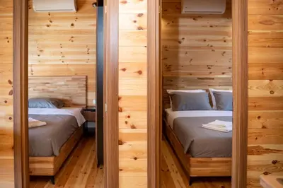 two beds in a room with wooden walls at River house - Esperanza in Ulcinj