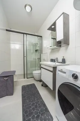 a bathroom with a toilet and a sink and a washing machine at Sunset Marina in Bar
