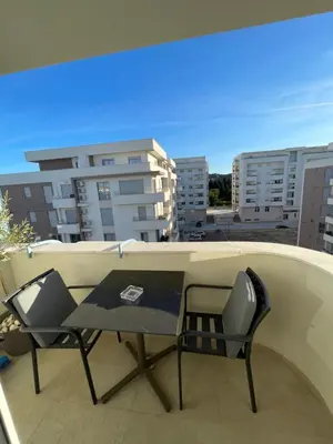 a table and chairs on a balcony with buildings at Apollo 2 in Ulcinj