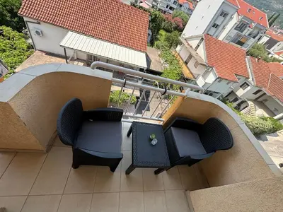 a balcony with two chairs and a television on it at Apartment Saint Tropez Budva, Privatna garaža in Budva