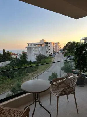 a table and chairs on a balcony with a view of a street at Villa Marmo in Ulcinj