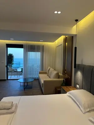 a bedroom with a bed and a living room with a couch at Villa Marmo in Ulcinj