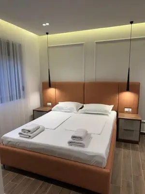a bedroom with a large bed with towels on it at Villa Marmo in Ulcinj