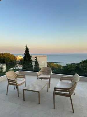 three chairs and a bench on a balcony with the ocean at Villa Marmo in Ulcinj