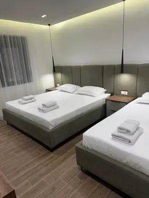 a bedroom with two beds with white sheets at Villa Marmo in Ulcinj