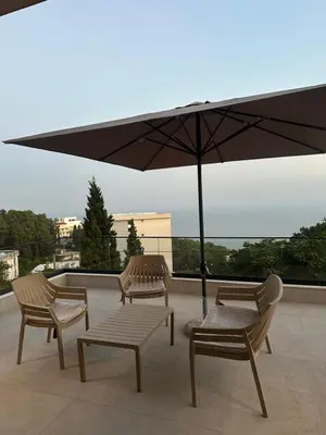 three chairs and an umbrella on a roof at Villa Marmo in Ulcinj