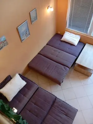a room with three beds in a room with a window at Budva Center Studio in Budva