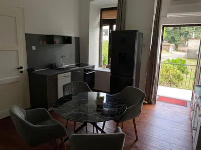 a kitchen with a table and chairs and a kitchen with a refrigerator at Apartman Ela Podgorica in Podgorica