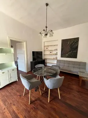 a living room with a table and chairs and a couch at Apartman Ela Podgorica in Podgorica
