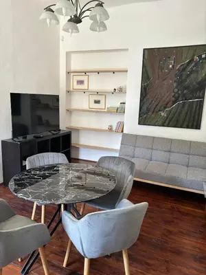 a living room with a glass table and chairs at Apartman Ela Podgorica in Podgorica
