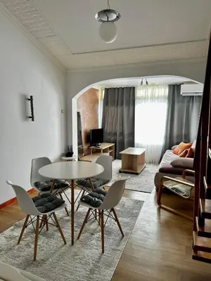 a living room with a table and chairs and a couch at Loft apartment Kapisoda in Budva
