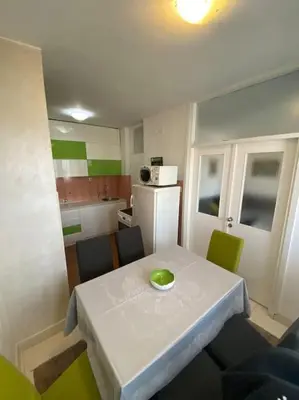 a small kitchen with a white table with a green bowl on it at Tea apartment in Podgorica