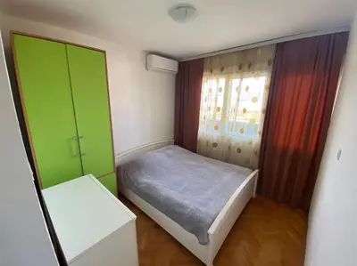 a small bedroom with a bed and a window at Tea apartment in Podgorica