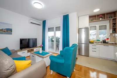 a kitchen and living room with a couch and a table at Two bedroom apartment Mali princ in Budva