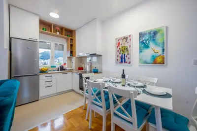 a kitchen and dining room with a table and chairs at Two bedroom apartment Mali princ in Budva
