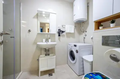 a bathroom with a washing machine and a sink at Two bedroom apartment Mali princ in Budva