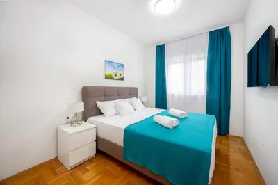a bedroom with a bed with a blue blanket at Two bedroom apartment Mali princ in Budva