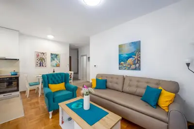 a living room with a couch and a table at Two bedroom apartment Mali princ in Budva