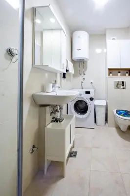 a bathroom with a sink and a washing machine at Two bedroom apartment Mali princ in Budva
