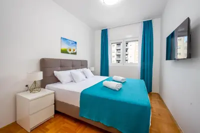 a bedroom with a bed with a blue blanket at Two bedroom apartment Mali princ in Budva
