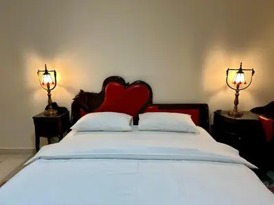 a bedroom with a bed with a red headboard and two lamps at Central 25 in Podgorica