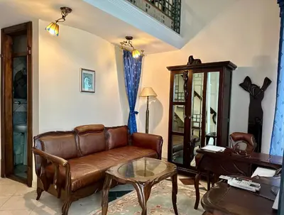 a living room with a leather couch and a table at Central 25 in Podgorica