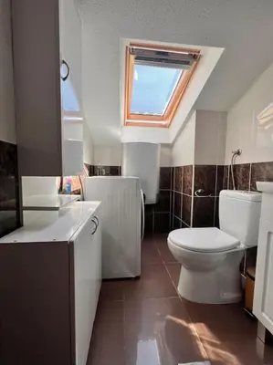 a bathroom with a toilet and a sink and a window at Apartment Marron Matou Budva in Budva