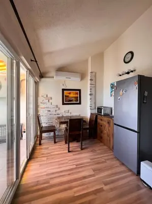 a kitchen with a refrigerator and a table with chairs at Apartment Marron Matou Budva in Budva