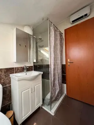 a bathroom with a shower and a sink and a mirror at Apartment Marron Matou Budva in Budva
