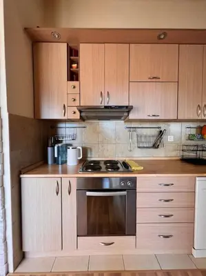 a kitchen with wooden cabinets and a stove top oven at Apartment Marron Matou Budva in Budva