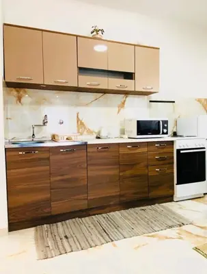 a large kitchen with wooden cabinets and a microwave at Karadag in Ulcinj