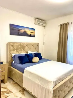 a bedroom with a large bed with blue pillows at Karadag in Ulcinj