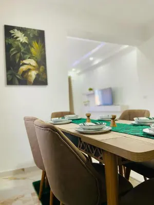 a dining room table with chairs and a table with plates at Karadag in Ulcinj