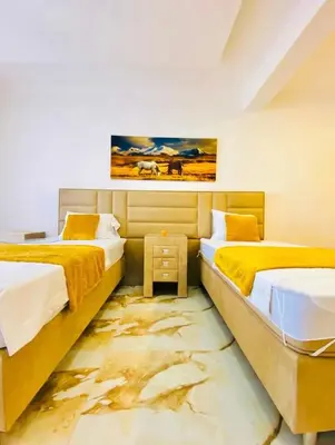 two beds in a room with a painting on the wall at Karadag in Ulcinj