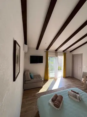 a bedroom with a bed and a couch in a room at Apartmani Mareta in Petrovac na Moru