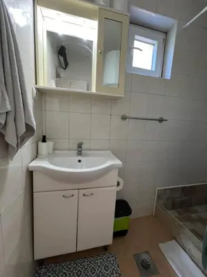 a white bathroom with a sink and a tub at Apartmani Mareta in Petrovac na Moru