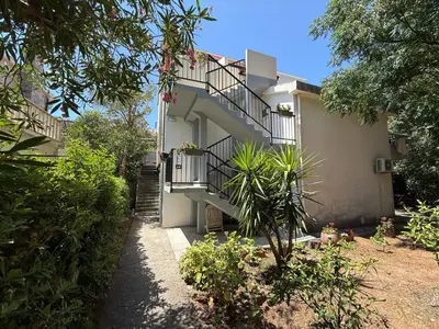 a building with a staircase and a balcony at Apartmani Mareta in Petrovac na Moru